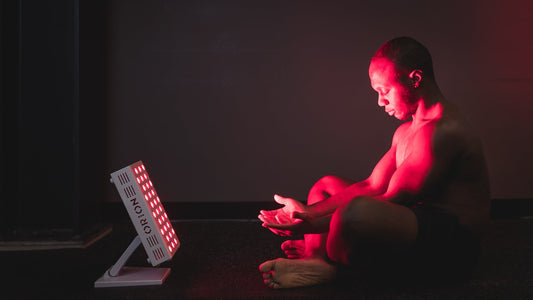 Person using Orion red light therapy to reduce delayed onset muscle soreness
